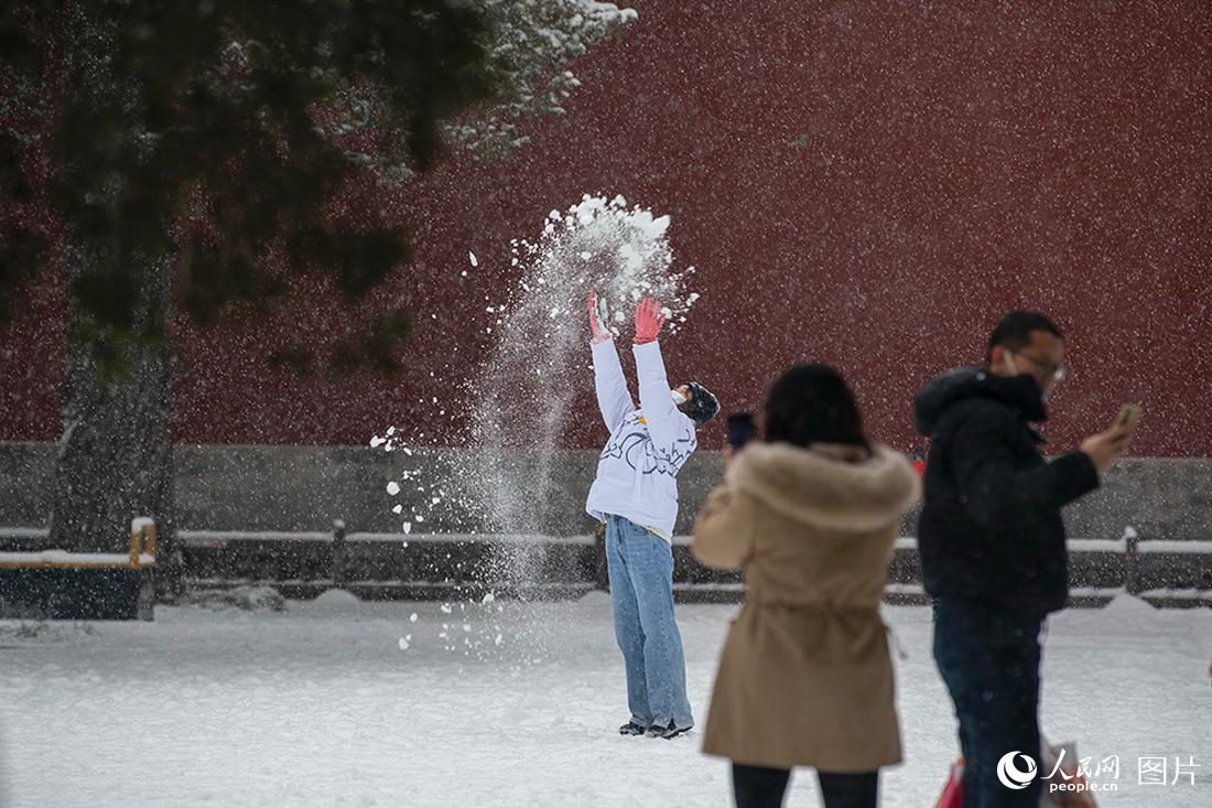 2月13日，在北京景山公园，游客在雪中撒欢。人民网记者翁奇羽摄