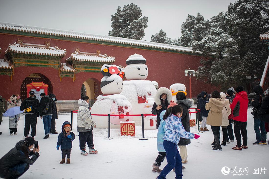 2月13日，在北京景山公园，游客尽享降雪带来的欢乐。人民网记者翁奇羽摄