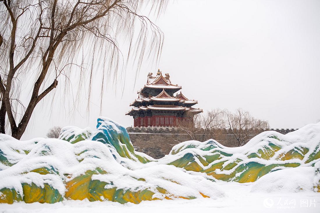 2月13日，雪中的故宫角楼与“千里江山图”景观雕塑相映成趣。人民网记者翁奇羽摄