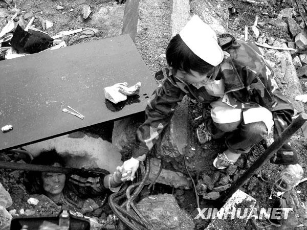 2008年5月13日，北川，一位护士不停地与一位被困孩子说话，鼓励他坚强活下去，等待救援。