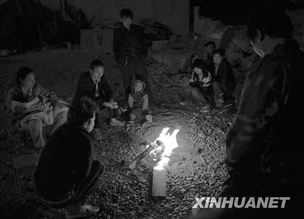 2008年5月13日凌晨，几位陇南受灾群众在烤火取暖。