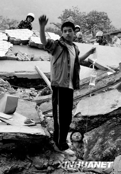 2008年5月13日6时许，北川中学高一学生李阳为被埋废墟的同学廖波拎着输液吊瓶。这幅照片传播甚广，照片中的李阳后来被人称为“吊瓶男孩”，而廖波则被称为“夹缝男孩”。