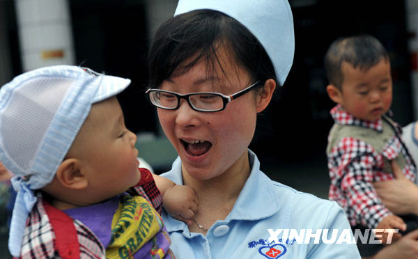 5月11日，护士王丽和“地震宝宝”陈鑫涛在一起。